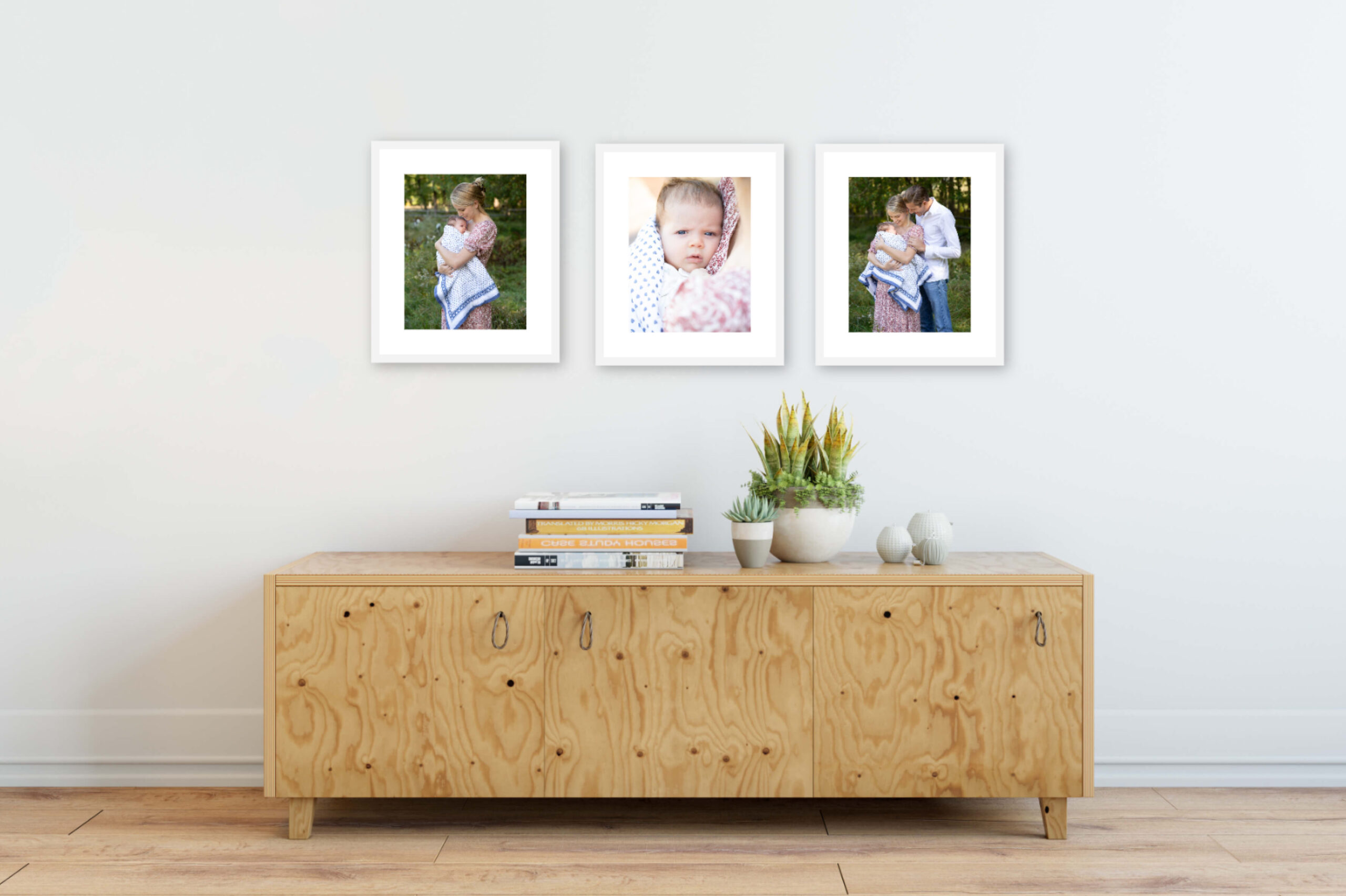 Framed pictures on the wall of a family with their newborn taken by a professional newborn photographer in Westchester, NY.